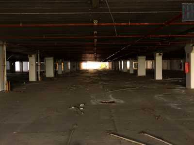 ...e ci avventuriamo nel parcheggio del primo piano: una vastissima distesa di asfalto puntellata dalle sole colonne bianche che reggono la parte sovrastante dell'immobile